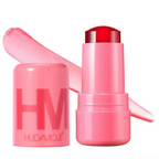 HUDA MOJI colorful lipstick collection featuring pink, coral, and red lipstick tubes with matching product packaging arranged on a soft pastel background.