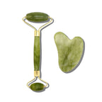 Green jade facial roller and heart-shaped gua sha stone for facial massage and skincare on a clean white background.