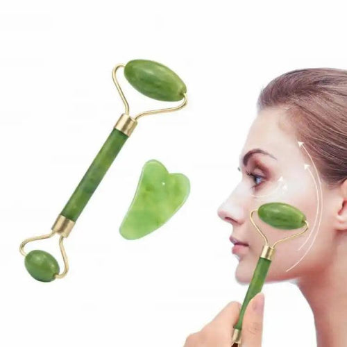 Green jade facial roller and heart-shaped gua sha stone for facial massage and skincare on a clean white background.