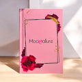 Mocallure Flower Palette in a pink floral book-style case displayed on a wooden surface. A 5-page all-in-one makeup palette featuring eyeshadows, blush, highlighter, concealer, and lipstick for complete makeup looks.