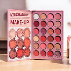 Mocallure Flower Palette in a pink floral book-style case displayed on a wooden surface. A 5-page all-in-one makeup palette featuring eyeshadows, blush, highlighter, concealer, and lipstick for complete makeup looks.