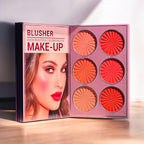 Mocallure Flower Palette in a pink floral book-style case displayed on a wooden surface. A 5-page all-in-one makeup palette featuring eyeshadows, blush, highlighter, concealer, and lipstick for complete makeup looks.