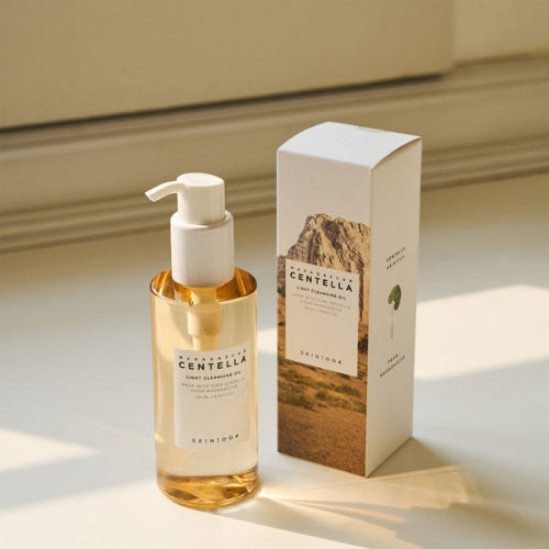 SKIN1004 Madagascar Centella Light Cleansing Oil bottle with pump and matching product box on a softly lit neutral background.